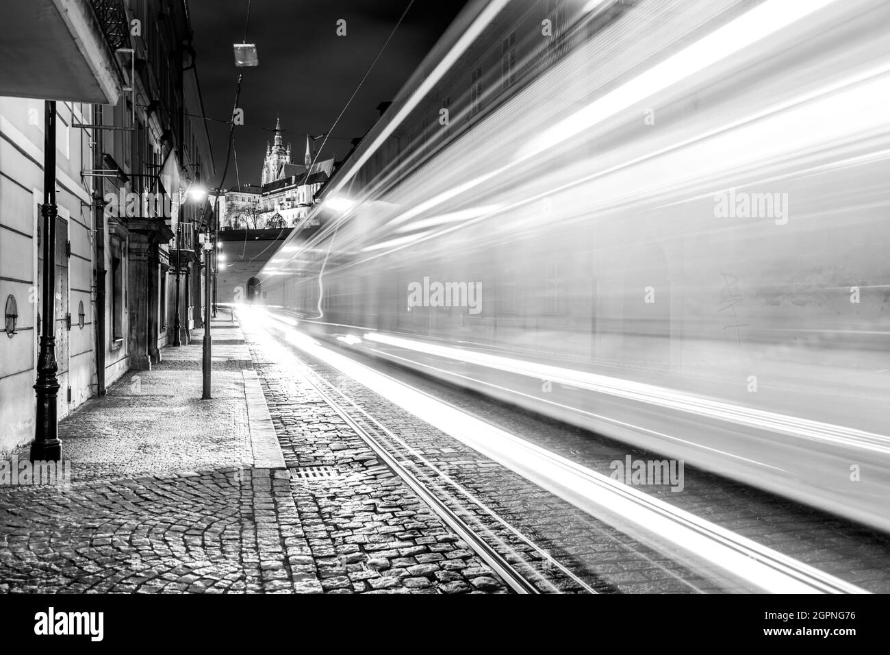 Night tram in Prague. Motion blurred tram in Letenska Street, Lesser Town of Prague, Czech Republic. Black and white image. Stock Photo