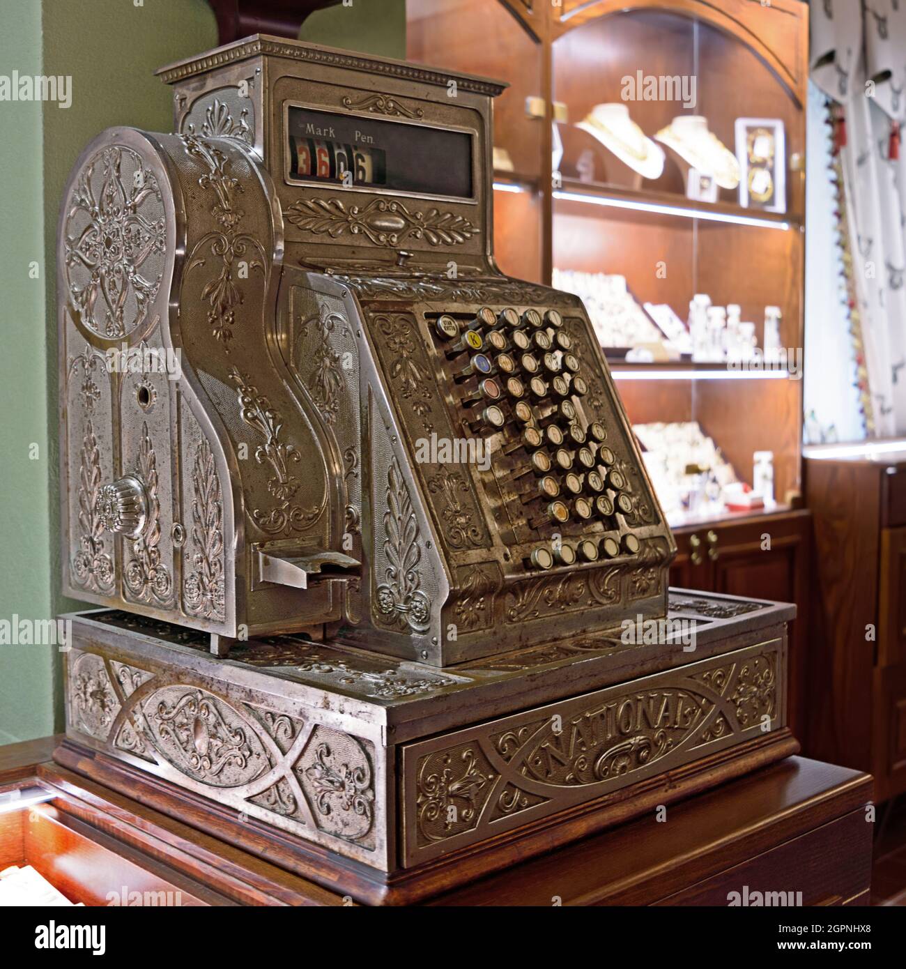 Oldtime cash register in a shop. Oldfashioned German engraved metal