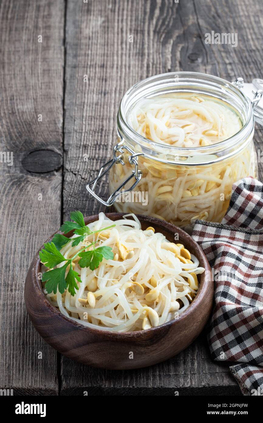 Marinated  sprouted mung beans in wooden bowl on rustic table Stock Photo