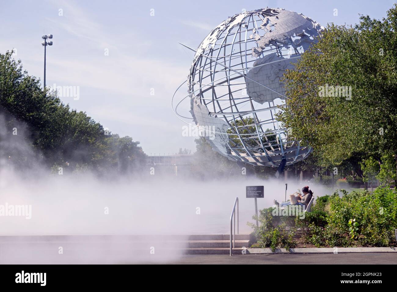 2 girls sitting and reading adjacent to the Fountain of the Fairs and near  the Unisphere. In Flushing Meadows Corona Park in Queens, New York Stock  Photo - Alamy