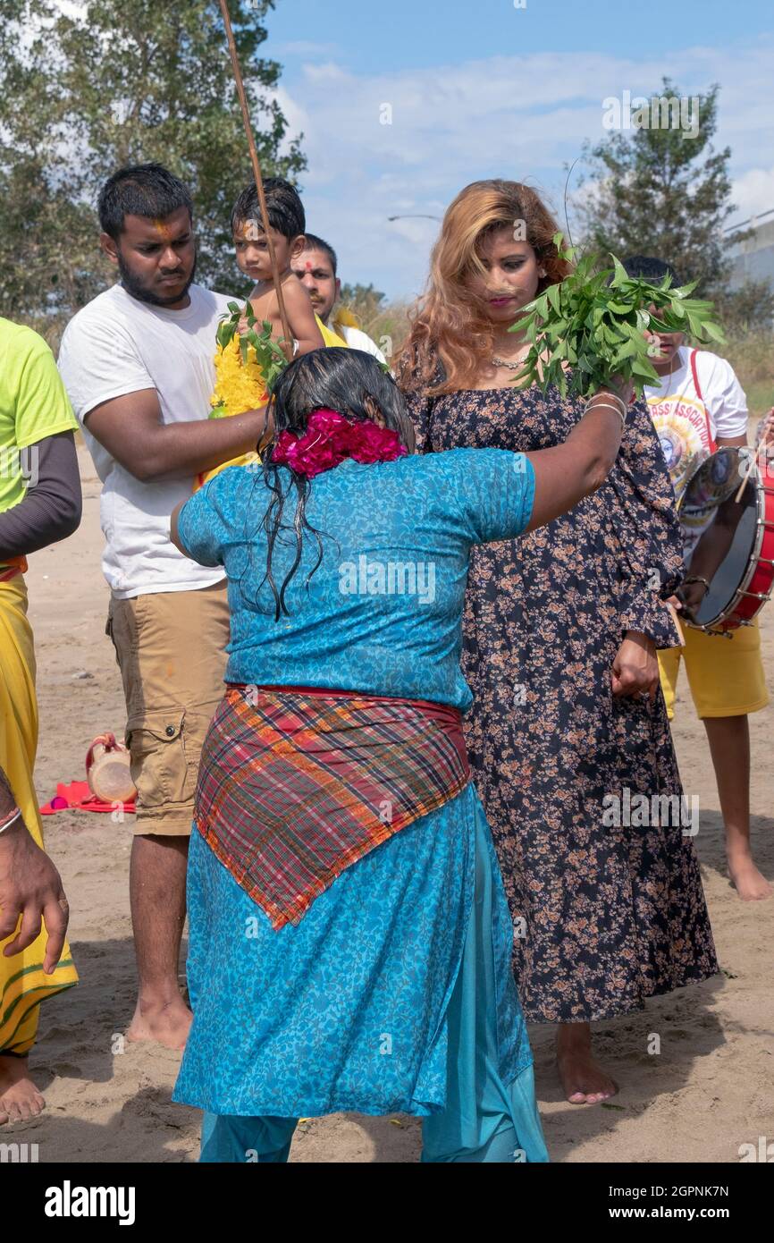 Hindu American men & women worshippers perform a cleansing  ritual at a Ganga and Kateri Amma Poosai service at Jamaica Bay in Queens, New York City. Stock Photo