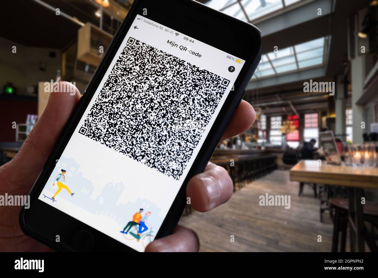 Smartphone with QR code of Dutch Corona Check app in restaurant: proof for negative test or corona vaccination for use in the Netherlands. Isolated on Stock Photo