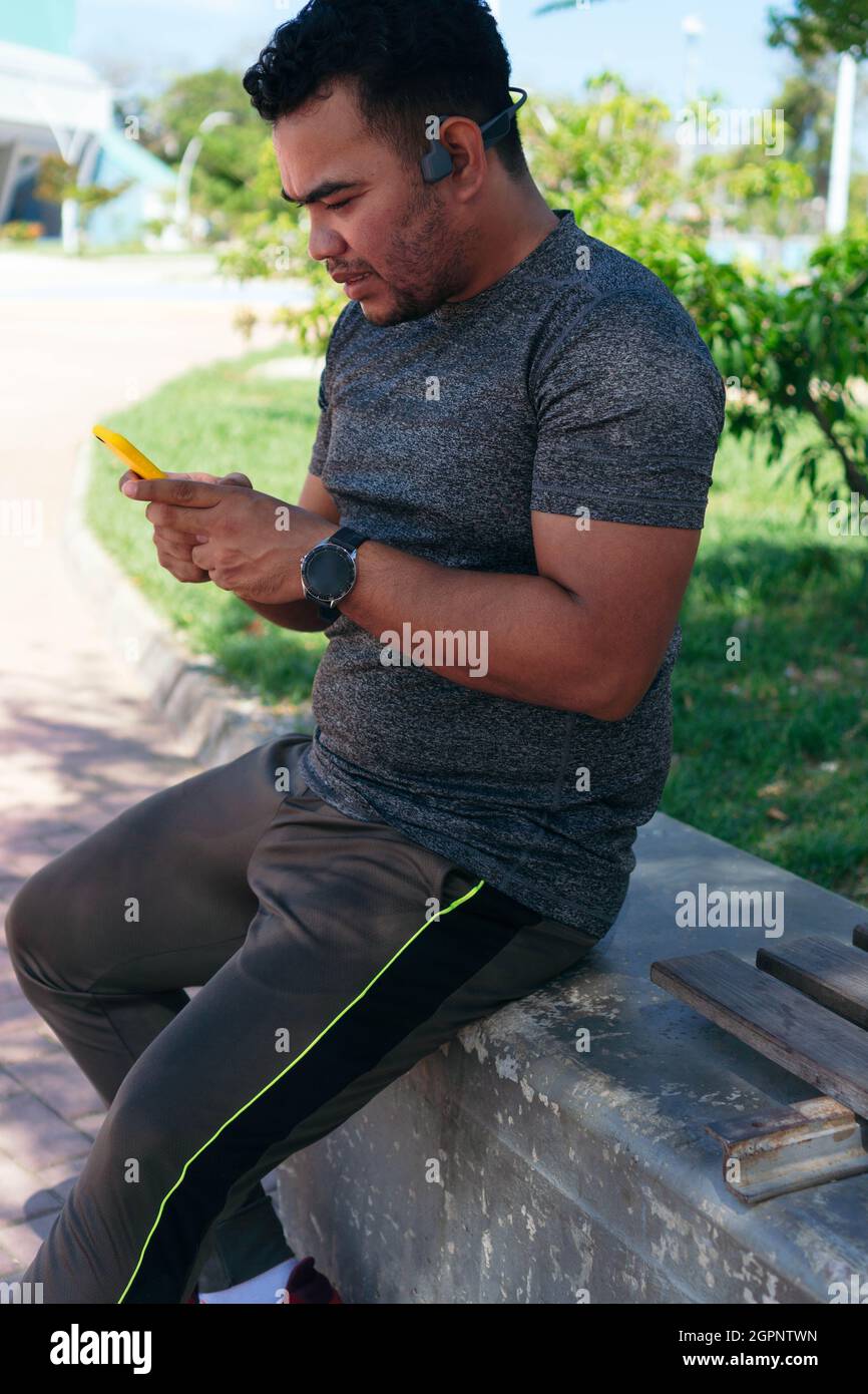 Hispanic Man checking his cell phone while training outdoors Stock ...