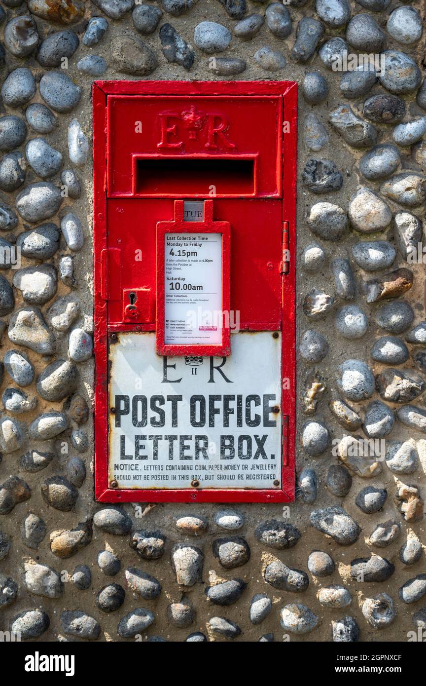 An old ER royal mail red post box set in a flint wall in Norfolk UK Stock Photo