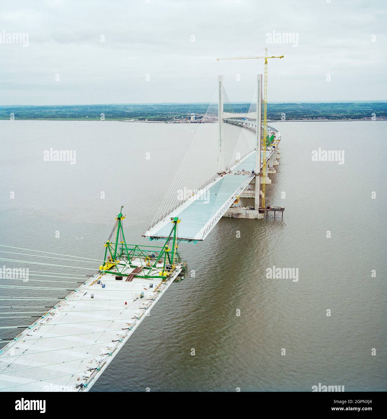 A view looking east from near the top of the Second Severn Crossing during its construction, showing cables supporting the deck of the bridge and work being carried out to join the deck units. The Second Severn Crossing took four years to build and was a joint civil engineering project between Laing Civil Engineering and the French company GTM. The work started in April 1992 and the opening ceremony later took place on 5th June 1996. The crossing is a cable-stayed bridge which stretches over 5000 metres across the River Severn connecting England and Wales, 3 miles downstream from the Severn Br Stock Photo