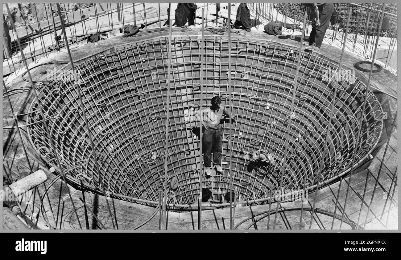 Workers constructing the preliminary mixers at Shoreham Cement Works. John Laing &amp; Son Ltd built a new cement works for Associated Portland Cement Manufacturers Ltd at this chalk quarry in Upper Beeding near Shoreham-By-Sea, with work in the quarry starting in February 1949. The work on the site was varied and complex and included the construction of buildings at the cement works, rail sidings and a coal-handling plant. The typed label beneath the photograph reads 'Completion of inner ring of steel to underside of ring beam. The men at the bottom are preparing to bring up the inner lining Stock Photo