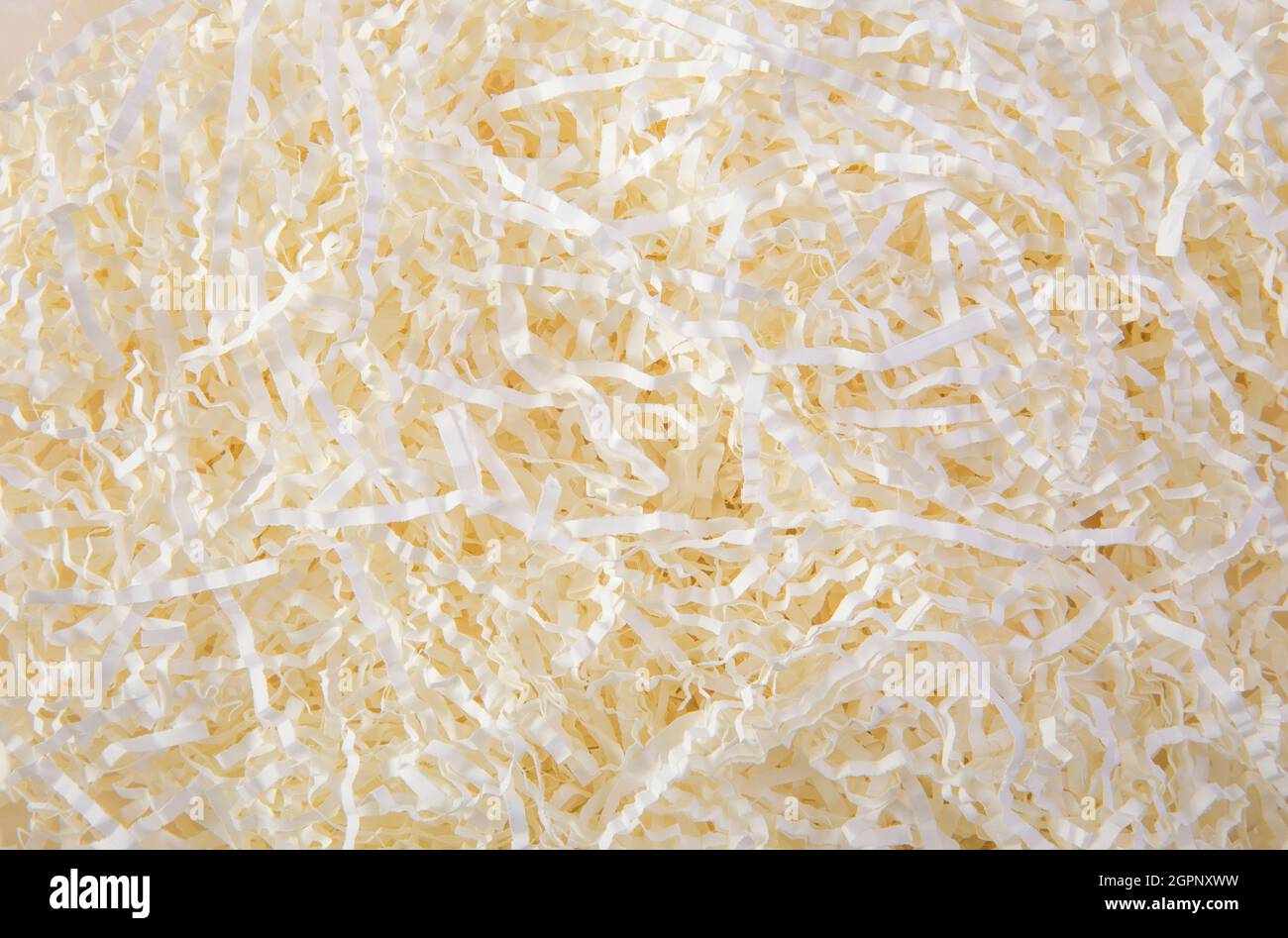 Cream color shredded paper - gift box filler background. Stock Photo