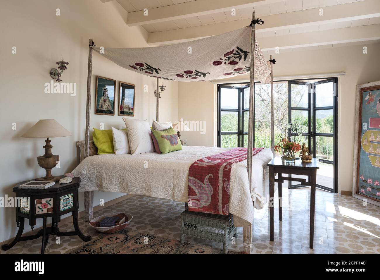 Floral canopy with red kantha throw on Goan four poster bed in Spanish