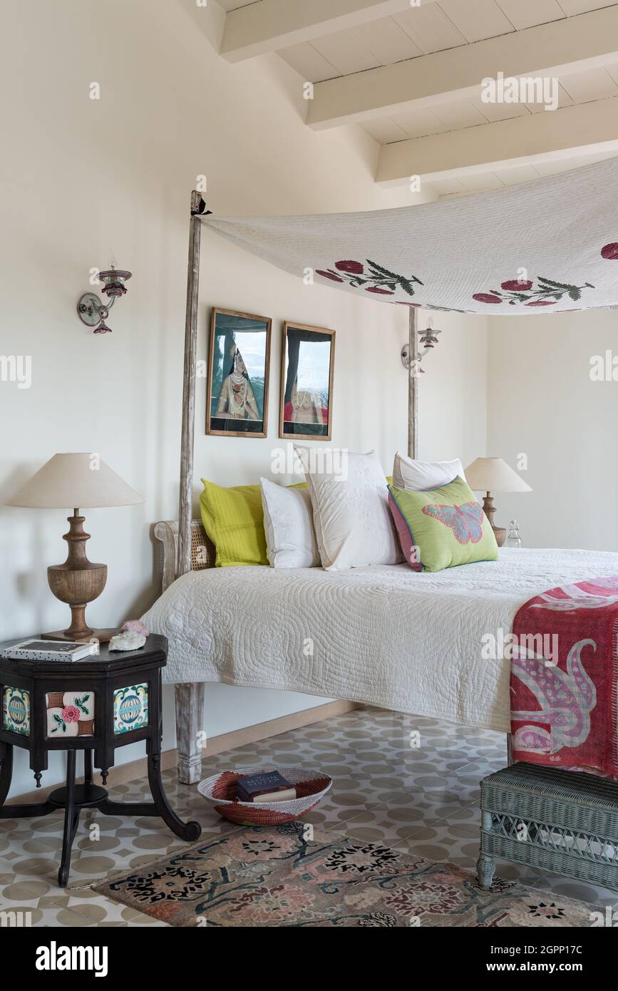 Floral canopy above Goan four poster bed with geometric tiles in Spanish villa, Mallorca Stock Photo