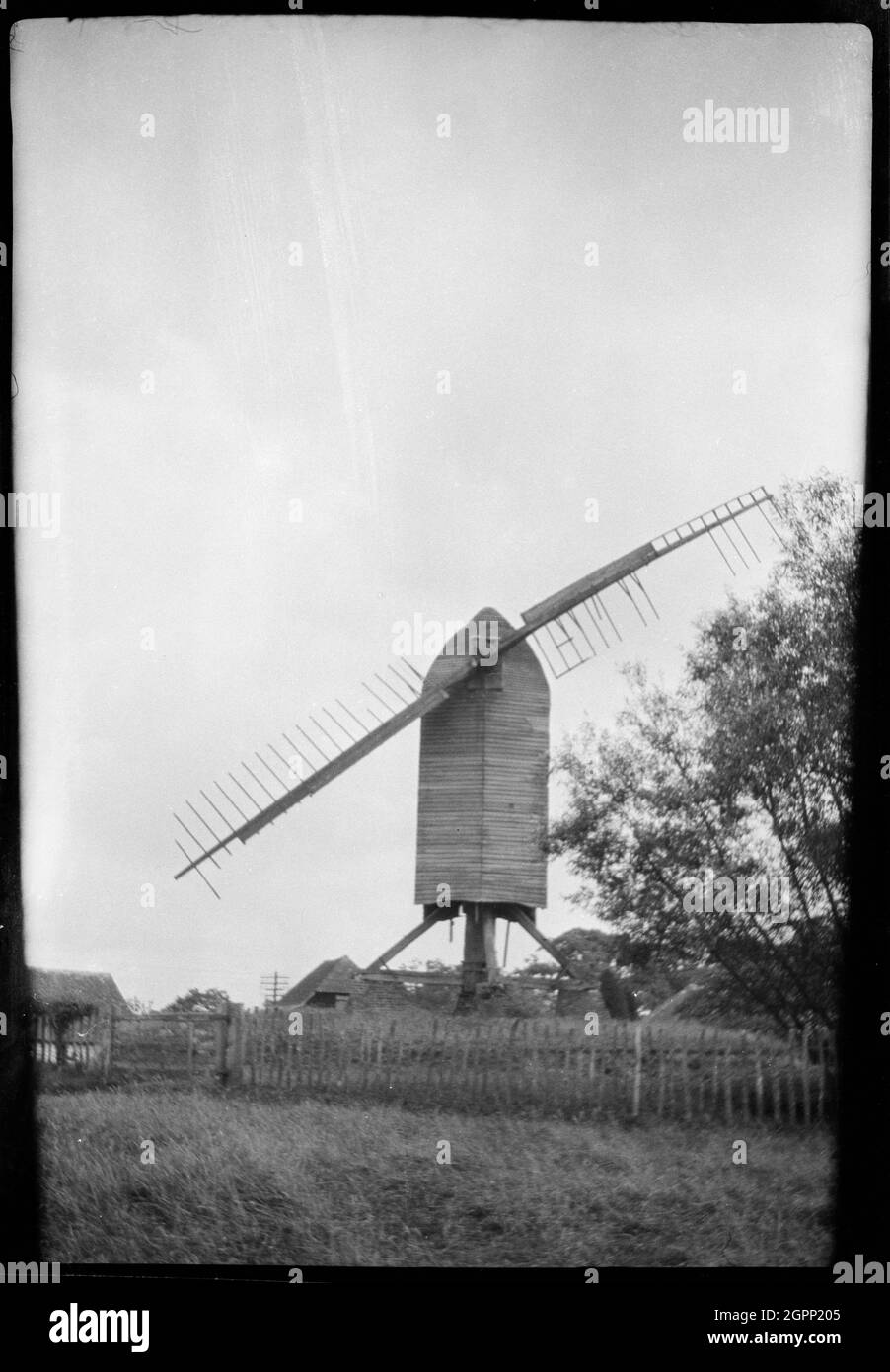 Rolvenden Mill, Benenden Road, Rolvenden, Ashford, Kent, 1932. A view of Rolvenden Mill, showing the post mill with two damaged sails. This post mill was built in the early 18th century, although one has existed on the site since about 1596. It ceased to work in 1883 and the original roundhouse was removed in the First World War. The mill was later restored in 1956. Stock Photo