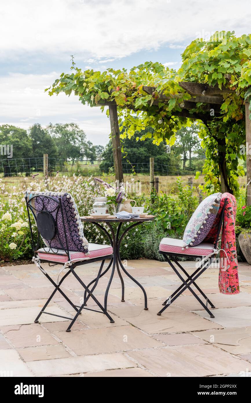 Indian cushions on folding chairs, Hampshire terrace, UK Stock Photo