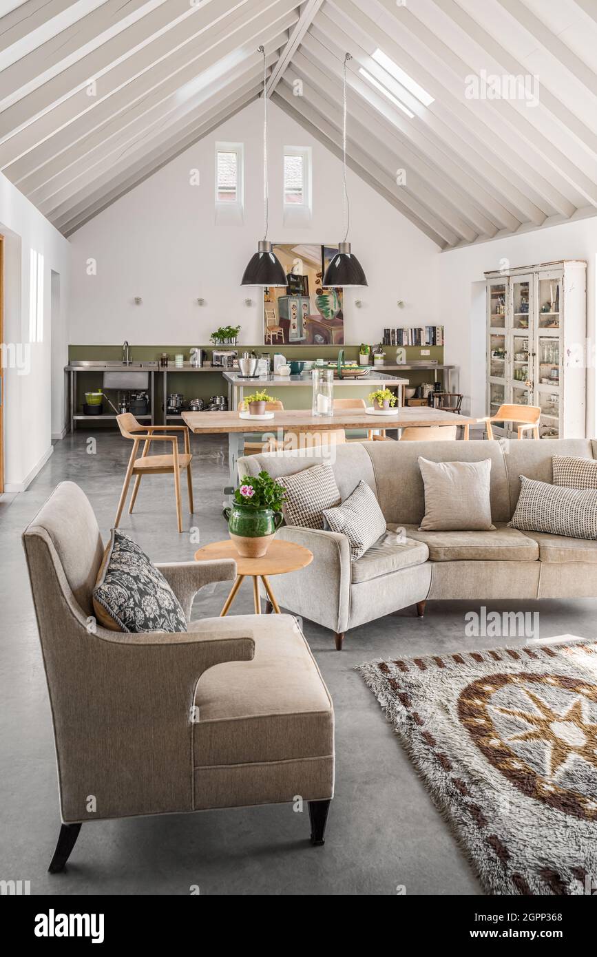 Mid century sof and armchair in newly built, double height Sussex farmhouse, UK Stock Photo