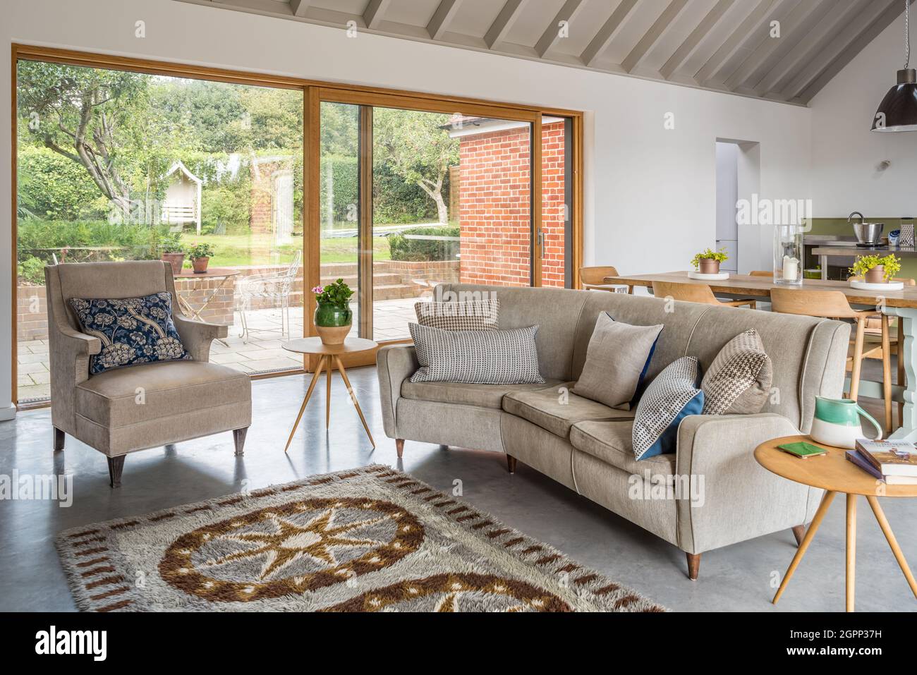 Mid century sofa and armchair with sliding doors in Sussex farmhouse, UK Stock Photo