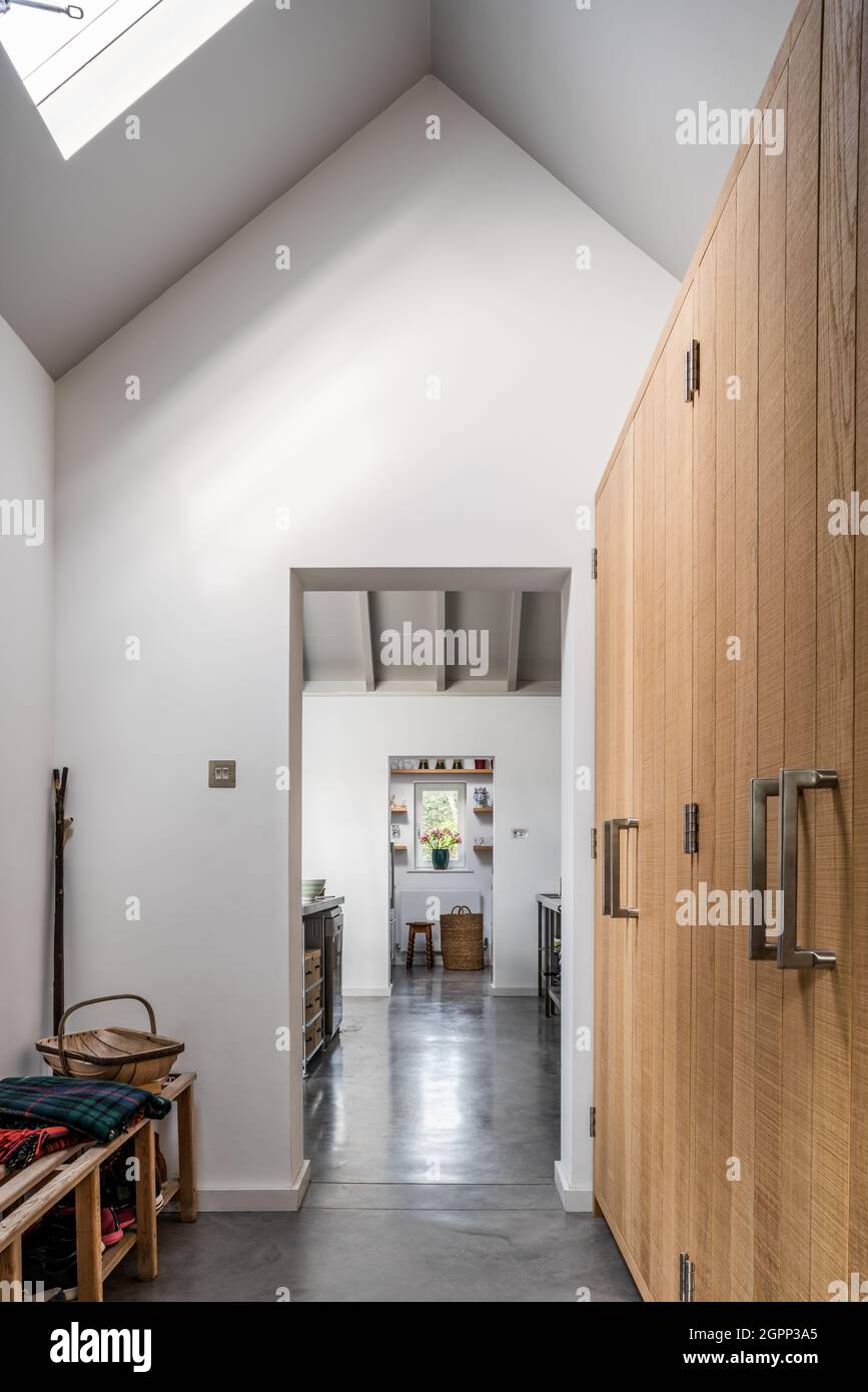 Entrance hall with wooden doors and concrete floor in new build Sussex barn, UK Stock Photo