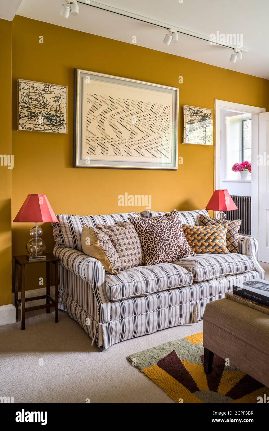 Striped sofa and modern British art in Sussex farmhouse, UK Stock Photo