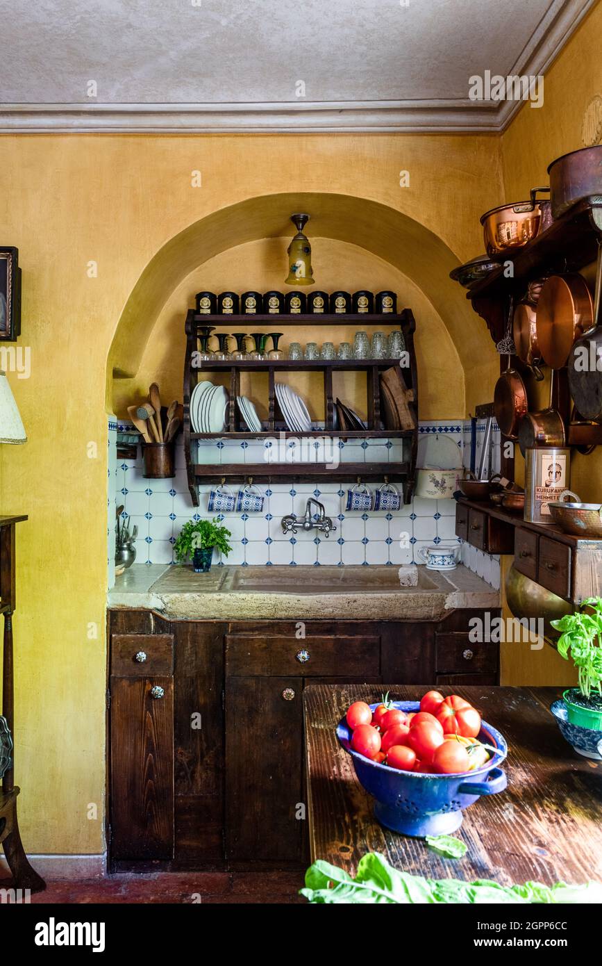 Copper pans with plate rack above sink, Lake Garda. Stock Photo