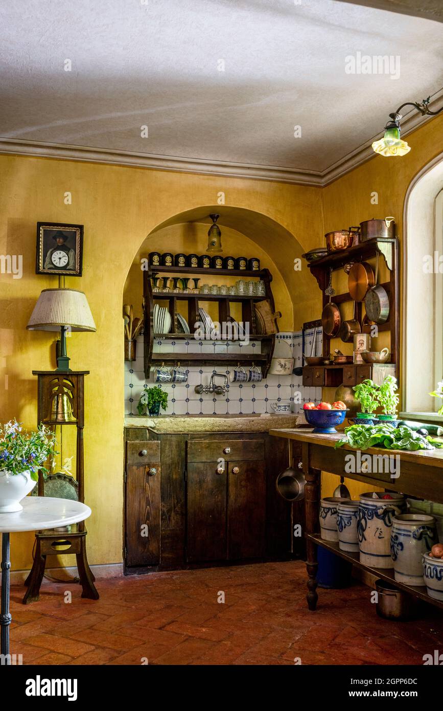 Kitchenware storage with blue and white pots under workbench in rustic kitchen, Lake Garda. Stock Photo