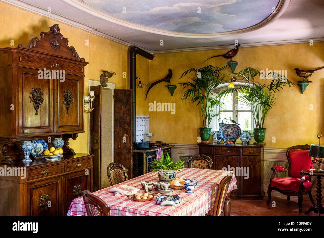 Peacock ornaments and wooden dresser with trompe l'oeil ceiling decoration in Lake Garda. Stock Photo