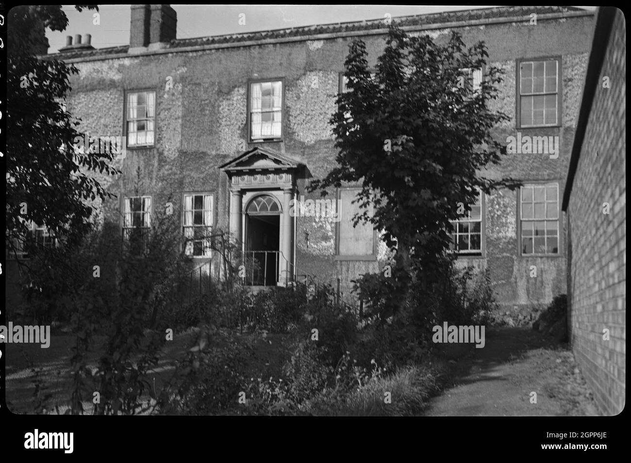 Clarence Hotel, Lead Yard, Darlington, 1942. An exterior view of the Clarence Hotel, which may have been situated on Lead Yard and demolished circa 1975. The image possibly shows the garden front, which had two storeys and a central door under a pediment. The hotel appears derelict. Lead Yard was situated south of St Cuthbert's Church and joined Feethams in the west. Stock Photo