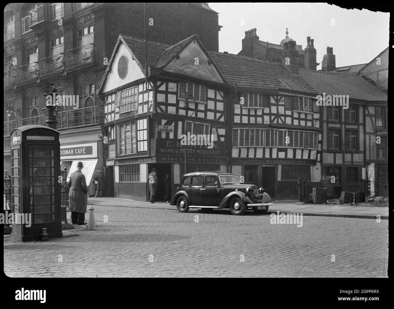 Old Wellington Inn, Old Shambles, Manchester, 1942. An exterior view of the Old Wellington Inn, showing the front facade in Old Shambles. The former house, now public house, dates to the mid 16th century, and was altered and raised by 30ft in the 1970s. It was moved c70m north to its current position, alongside Sinclairs Oyster Bar, in the mid to late 1990s, opening again in 1999. The inn has three storeys and a three bay plan, with the end bays gabled. There is a splayed door in the left corner, and a 20th century door in the centre of the south facade. The photo shows the inn in it's origina Stock Photo