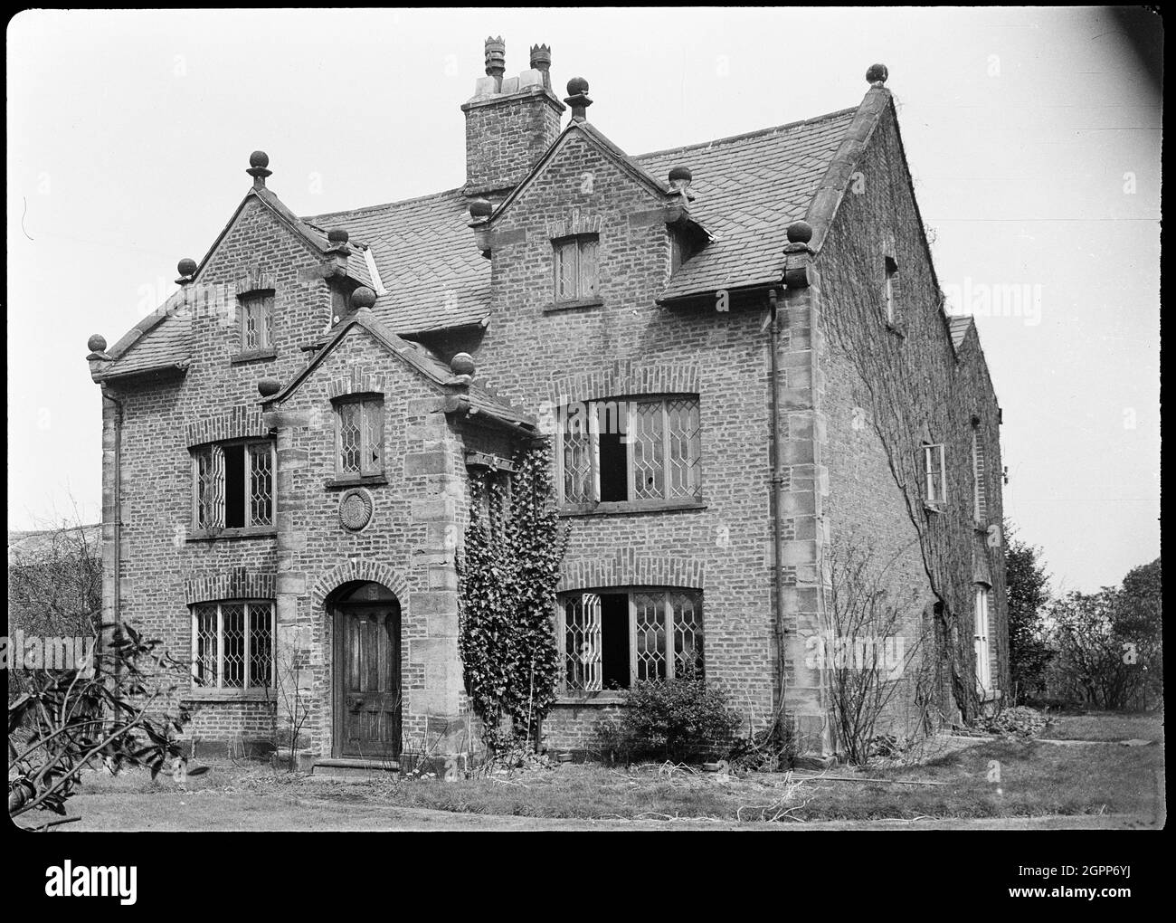 Knobb Hall, Manchester, 1942. An exterior view of Knobb Hall, showing the front facade. The hall was built in the c17th century, and was demolished post 1942. The front facade has three bays and two storeys, with attics in the two end gables. The porch was two storeys and projecting, with a gabled roof. The gables throughout the hall has ball finials on each corner. Stock Photo