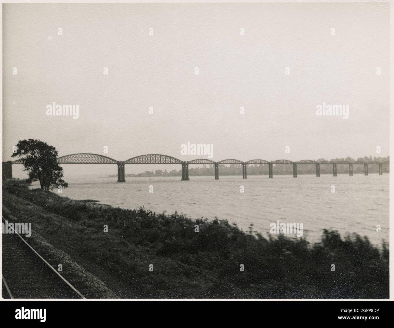 Severn Bridge, Lydney, Forest of Dean, Gloucestershire, 1951. The Severn Bridge, viewed from the South Wales Railway on the west bank of the River Severn. The Severn Bridge was opened in 1879, and carried the Severn and Wye Railway across the River Severn. In 1960, two barges collided with a bridge pier, and two spans collapsed. In 1961, during repair work, a similar collision occurred and it was deemed uneconomical to repair the bridge. It was demolished in the late 1960s. Following the opening of the Severn Road Bridge in 1966, the Severn Bridge is often referred to as the Severn Railway Bri Stock Photo