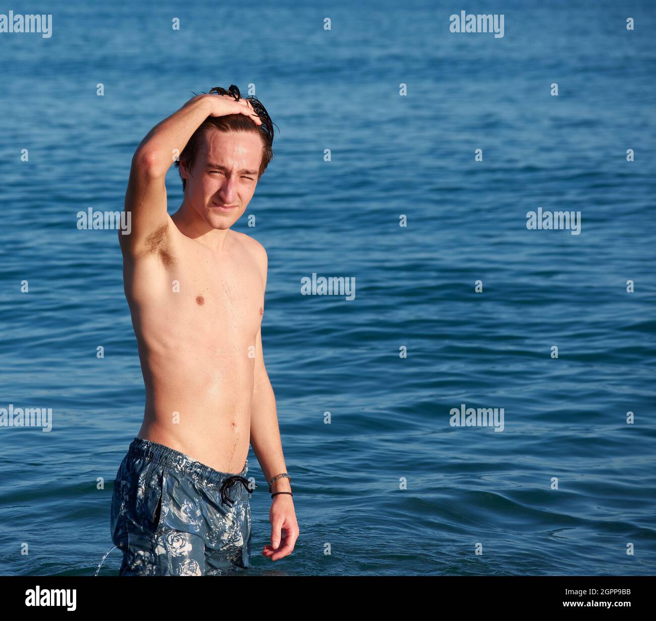A Spanish male standing in the seawater, posing and having fun Stock Photo Alamy