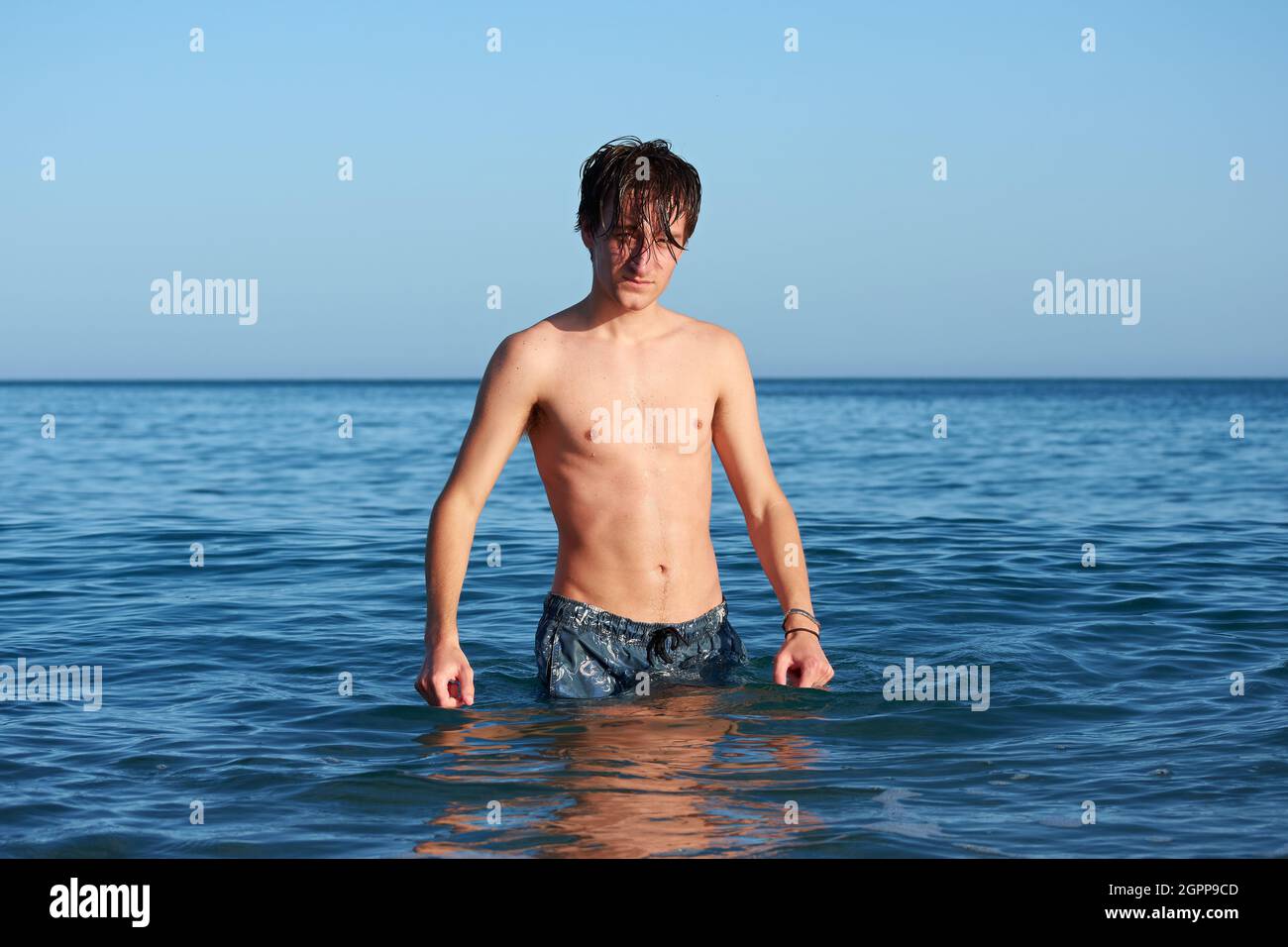 A Spanish male standing in the seawater, posing and having fun Stock Photo Alamy