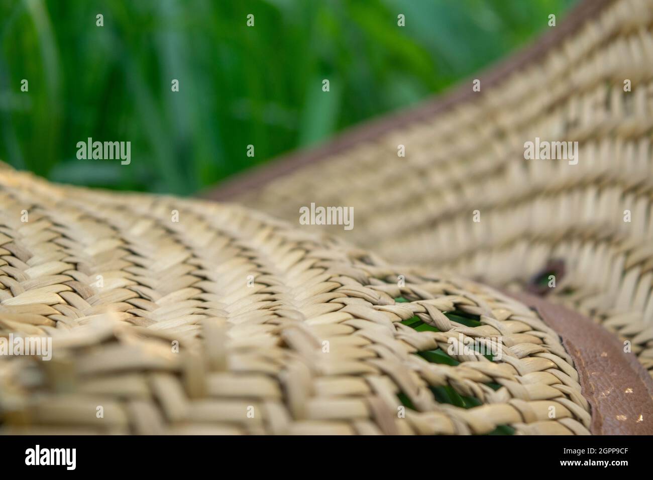An old straw hat on the green grass, close-up, selective focus Stock Photo