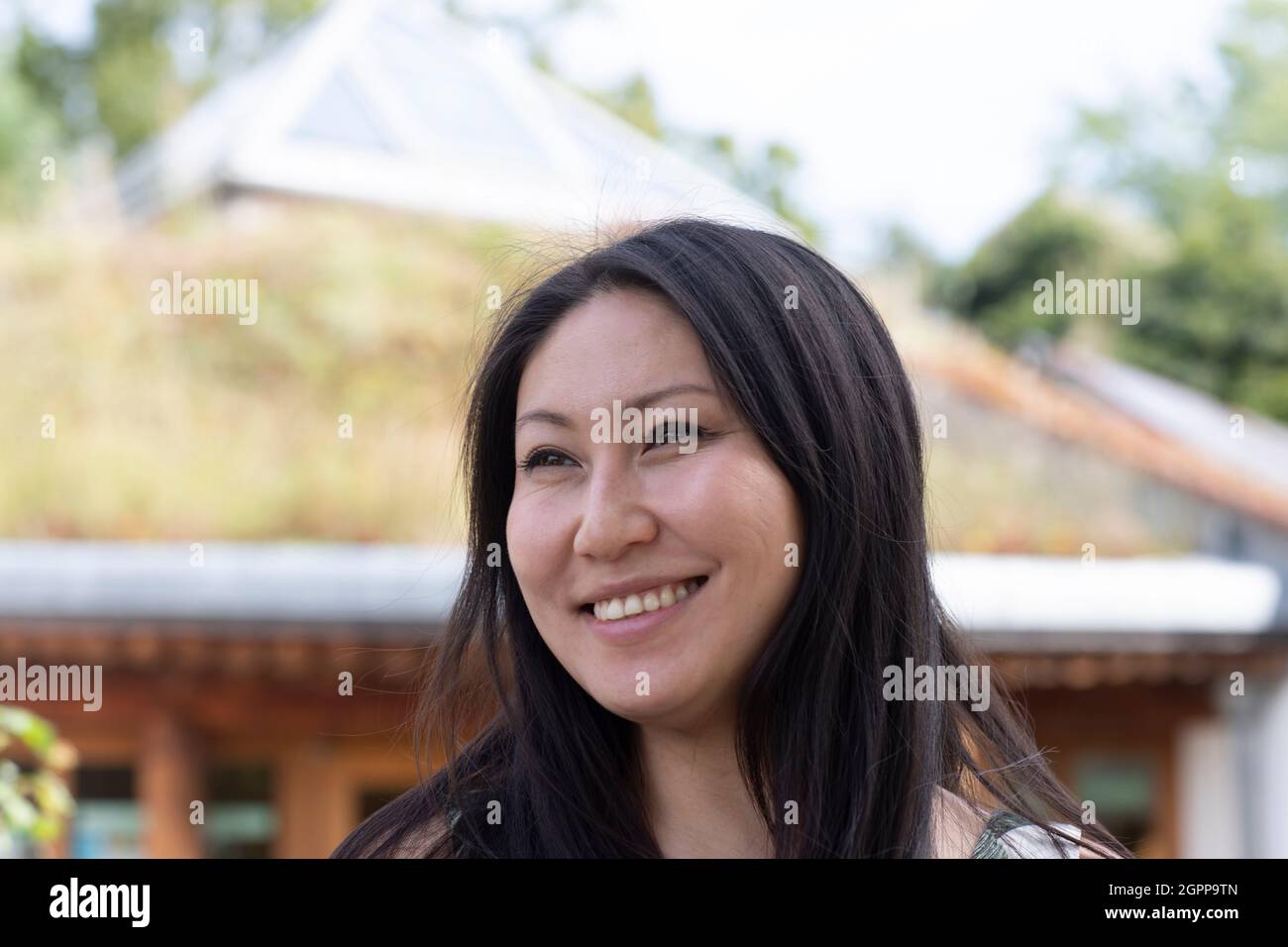 Germany, Freiburg, Portrait of smiling young woman outdoors Stock Photo