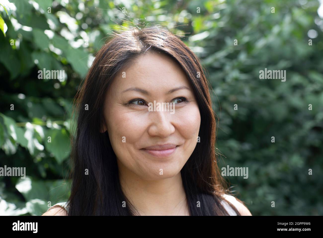 Germany, Freiburg, Portrait of smiling young woman outdoors Stock Photo