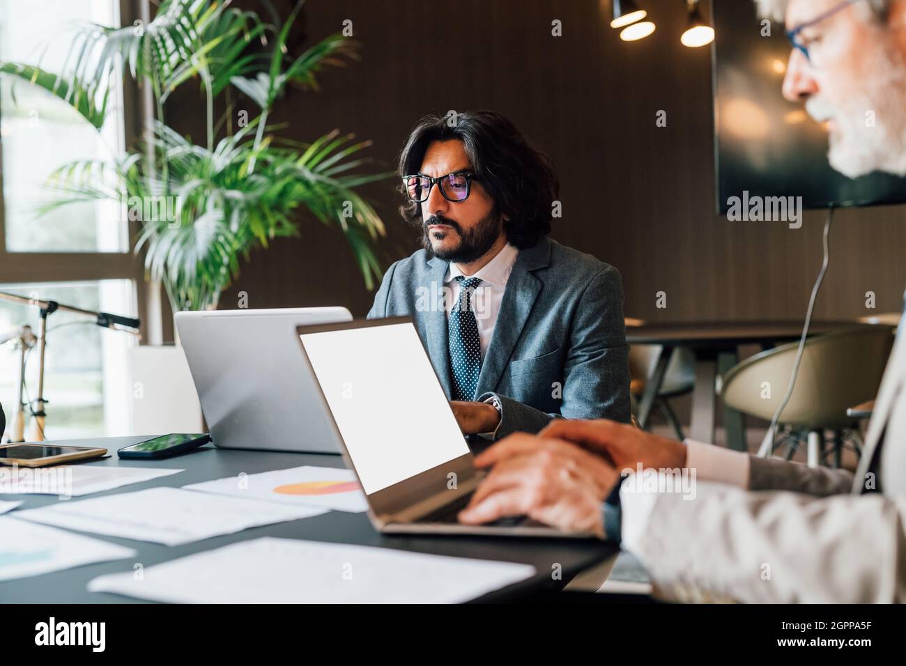 Italy, Businessmen using laptops in creative studio Stock Photo