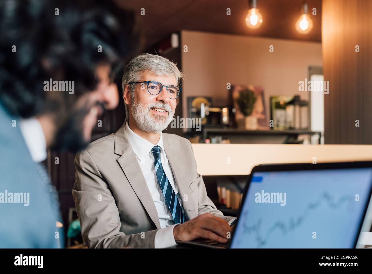 Italy, Businessmen using laptops in creative studio Stock Photo