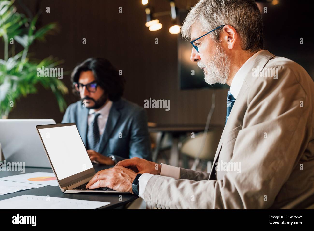 Italy, Businessmen using laptops in creative studio Stock Photo