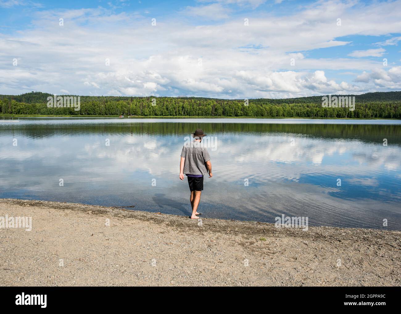 USA, Alaska, Rear view of man on lakeshore in Kenai Fjords National Park Stock Photo