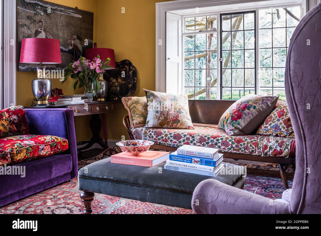Ercol daybed with mix of bold colours and fabrics in Suffolk living room. Stock Photo