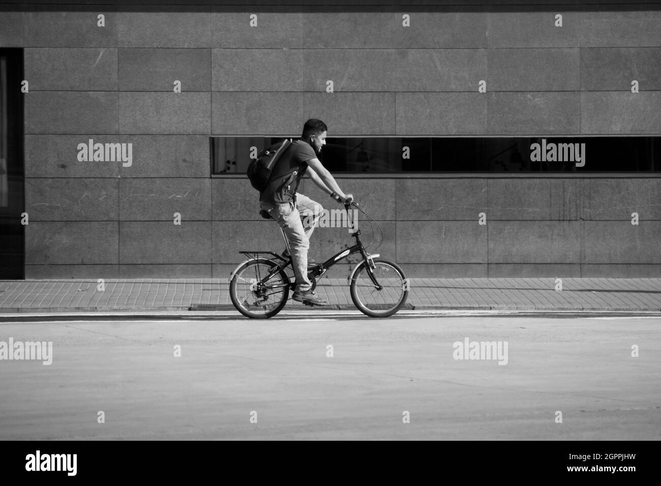 Man is riding a bicycle in a street during summer. Stock Photo