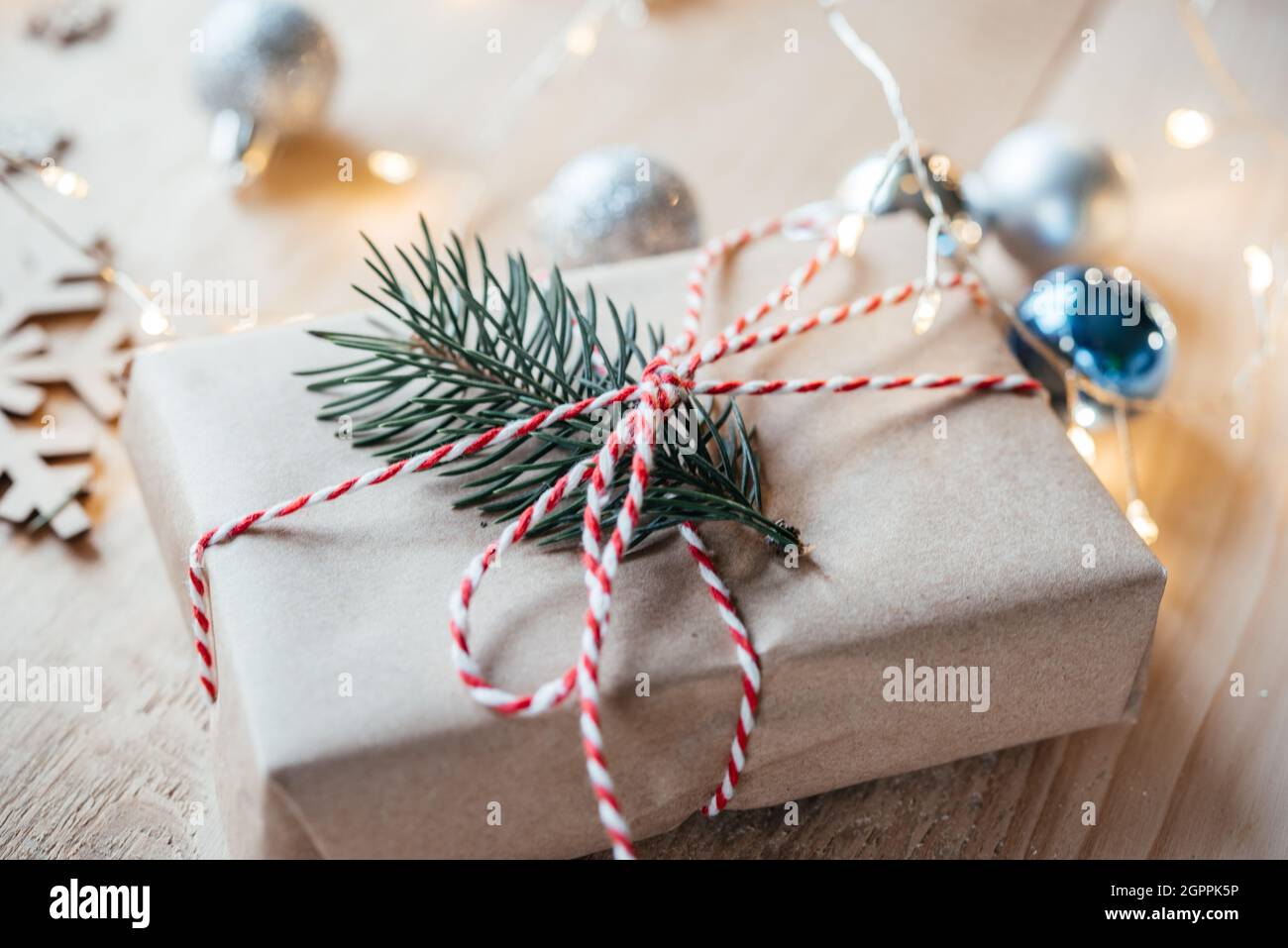 Christmas gift box wrapped in kraft paper with pine tree branch Stock Photo
