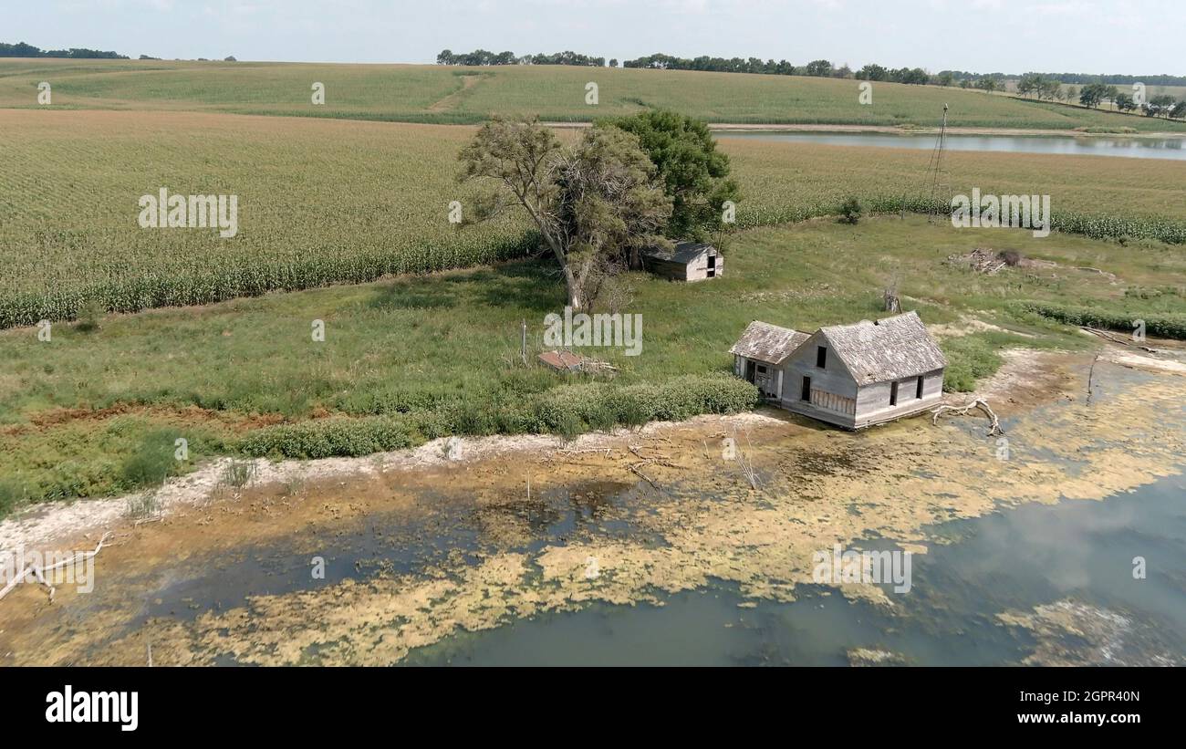 Low aerial view of an abandoned homestead and farm house in rural South