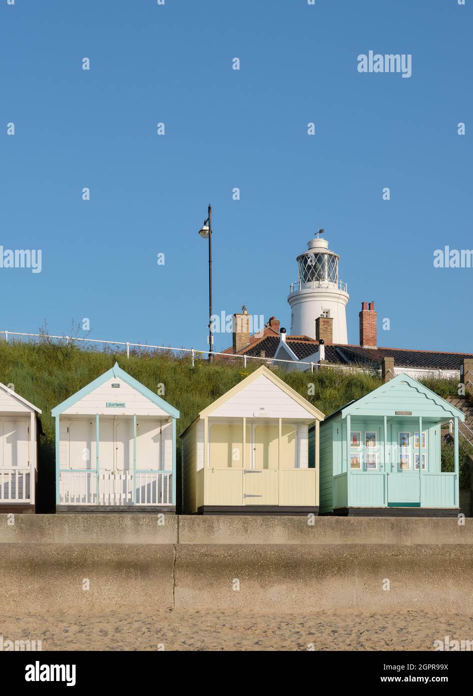 The colourful summer beach huts and the lighthouse at the seaside town