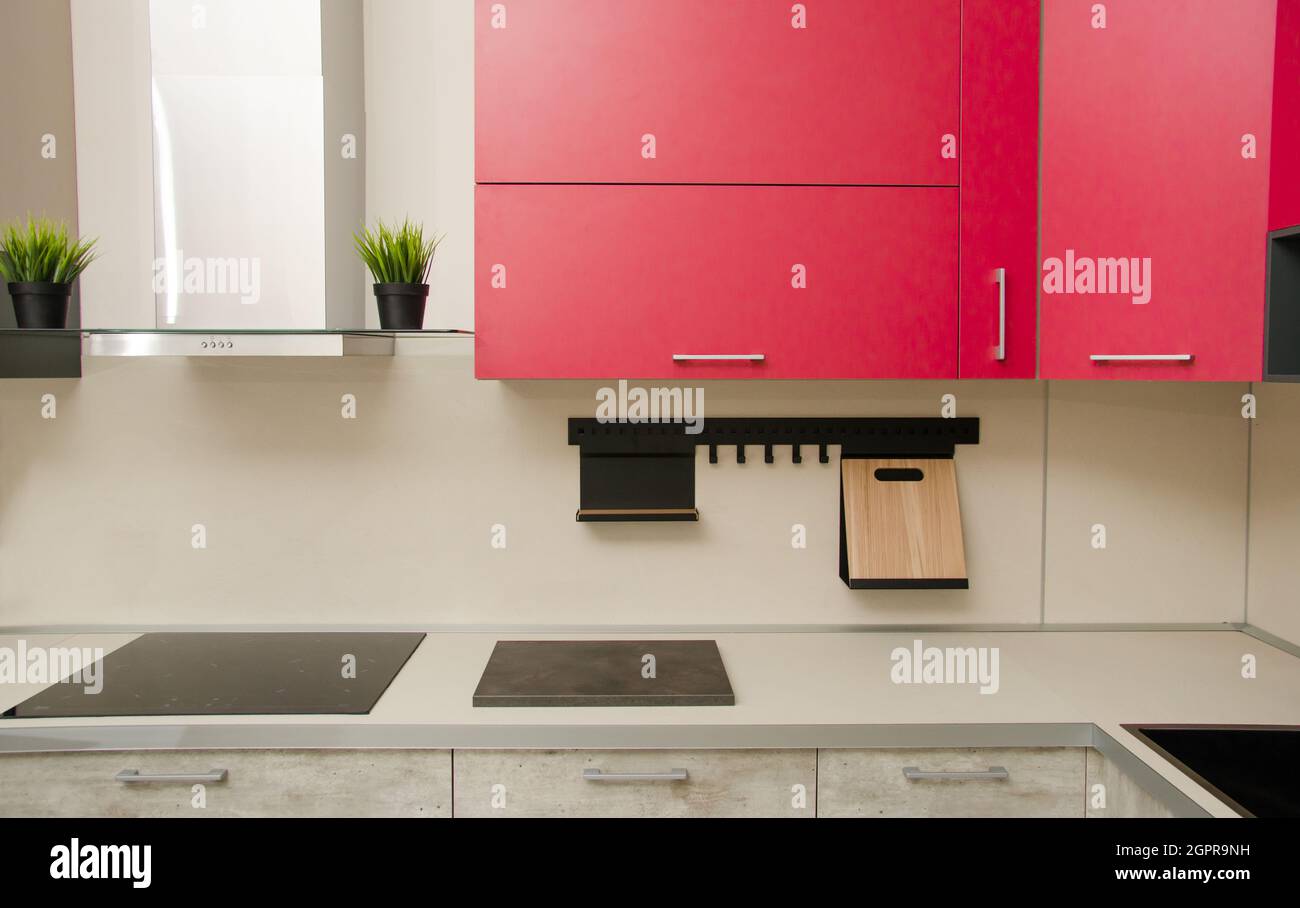 Modern Loft-style Kitchen With Red Cabinets, Stove, Range Hood And Table With Countertop. Stock Photo