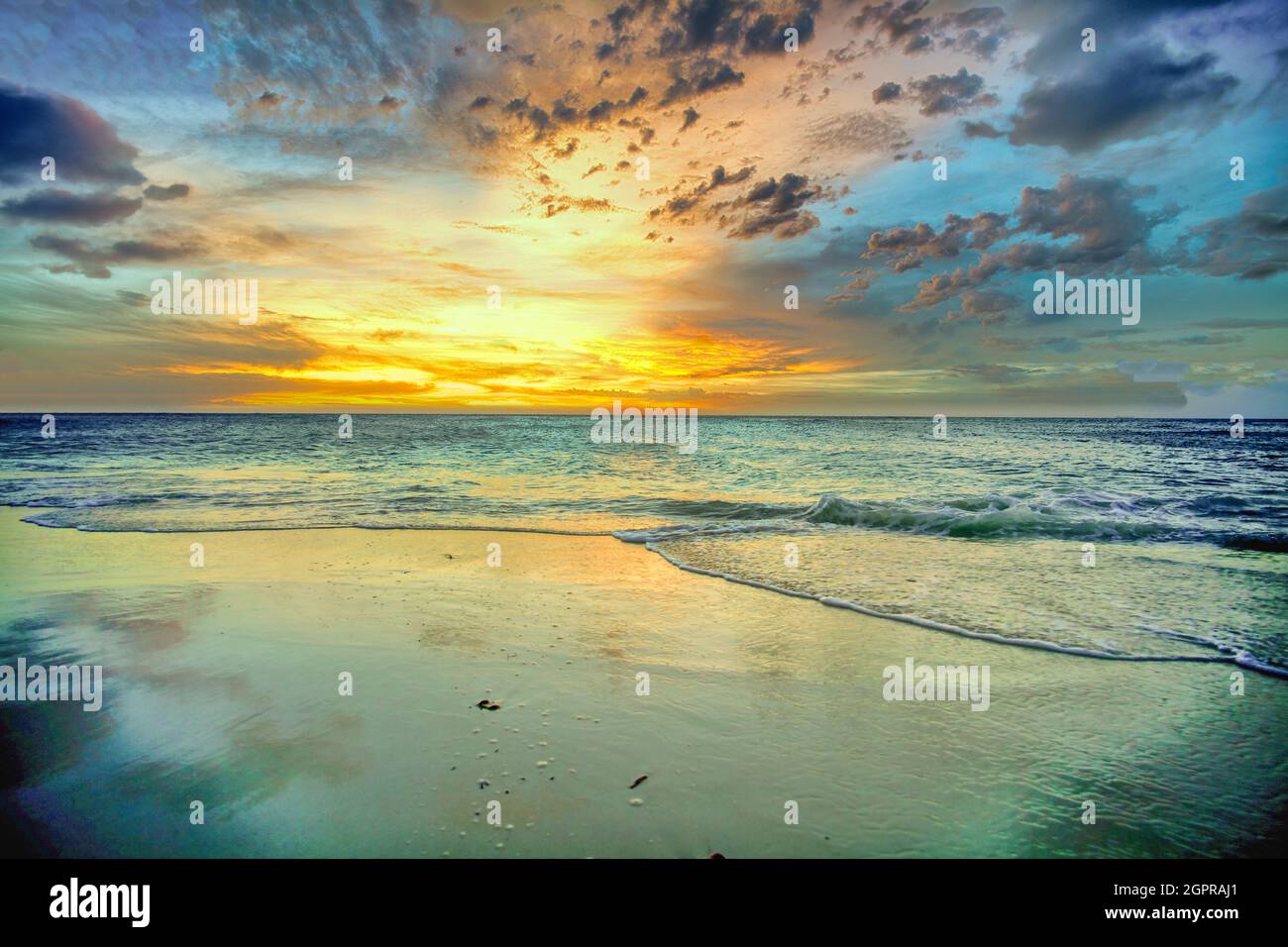 Idyllic sandy beach under a cloudy sunset sky Stock Photo - Alamy