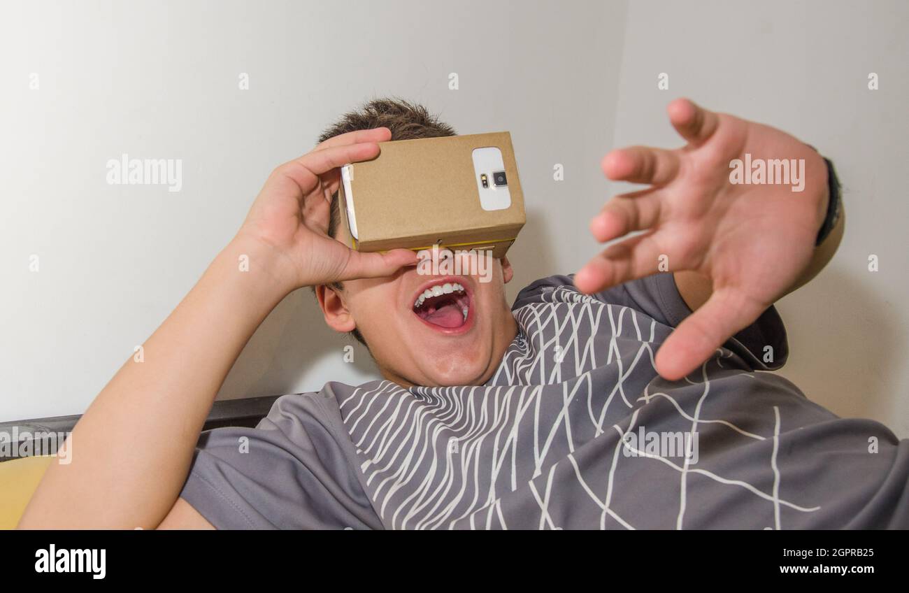 Happy Boy Watching In Smart Phone Through Cardboard Virtual Reality Simulator Stock Photo