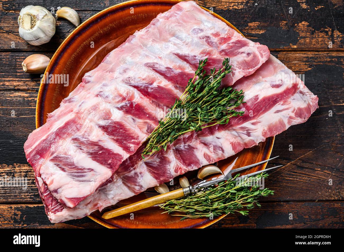 Raw pork loin spare ribs with thyme. Dark wooden background. Top view ...