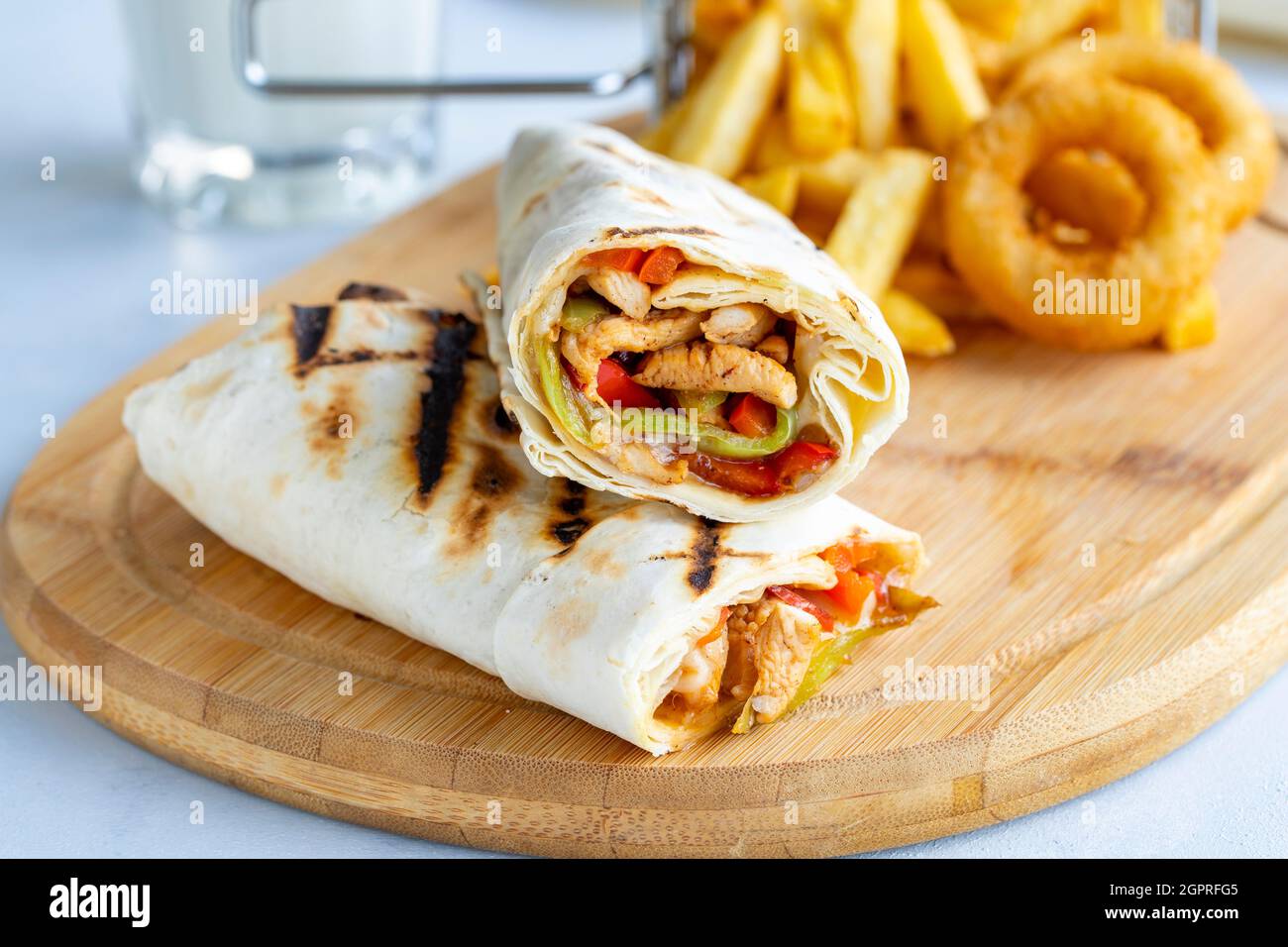 Chicken wrap on a white background. With french fries and onion rings Stock Photo