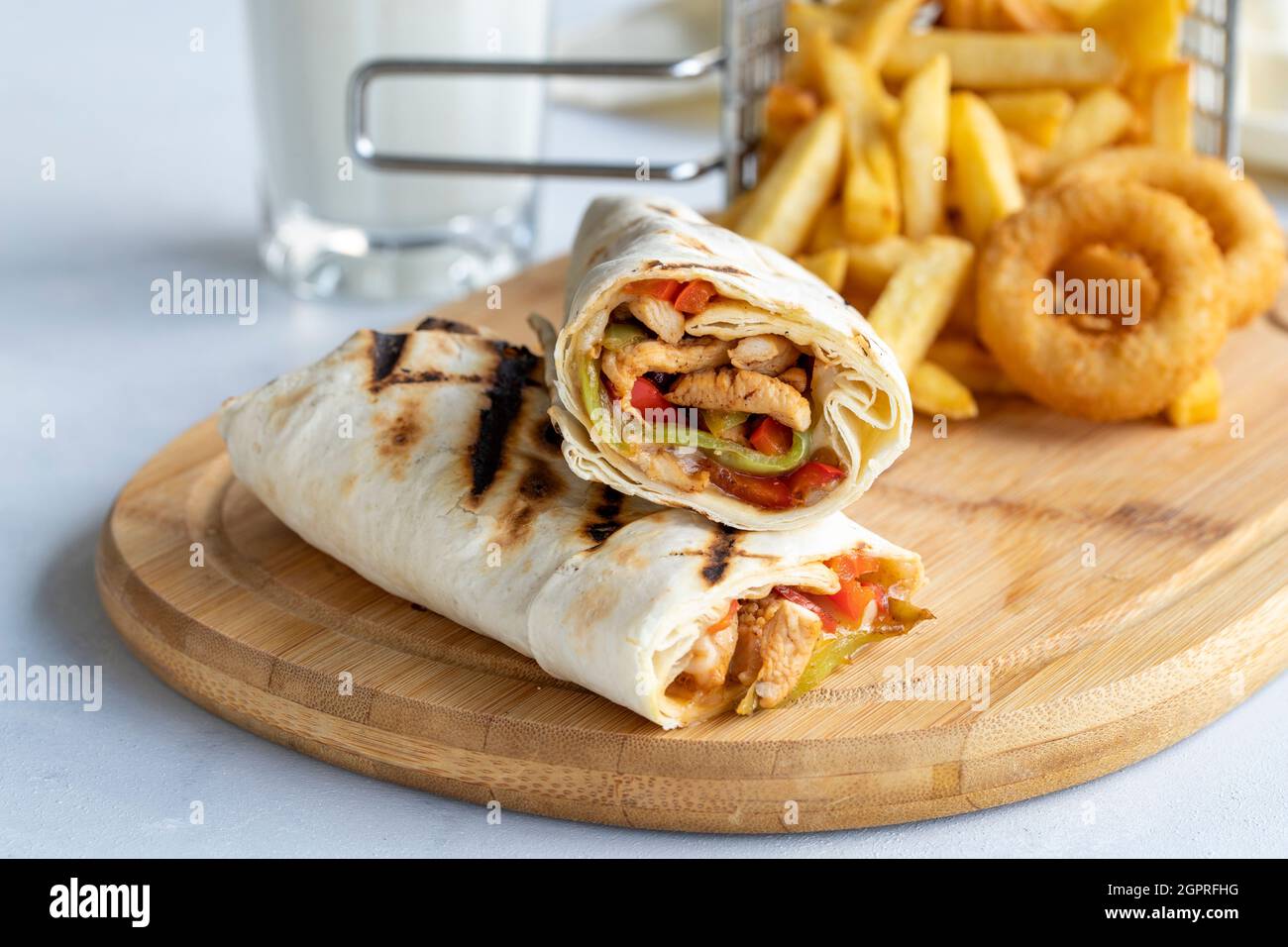 Chicken wrap on a white background. With french fries and onion rings Stock Photo
