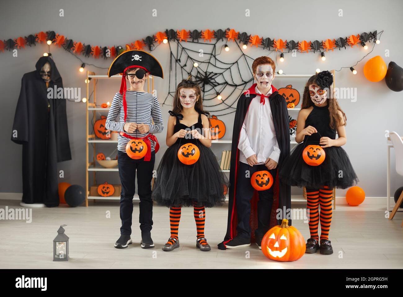 Group of children in carnival costumes with spooky makeup standing with  buckets for candy Stock Photo - Alamy