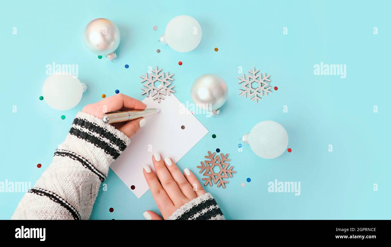 Top view of woman writing on blank greeting card.New year decor around,large banner. Stock Photo