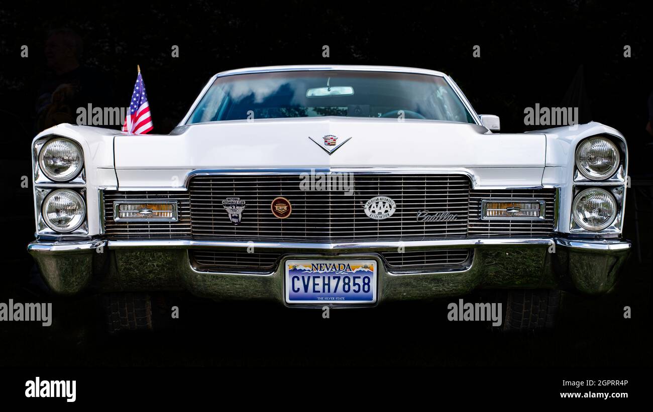 Classic Cadillac DeVille, white, with a Nevada plate, front view against a black background. Stock Photo