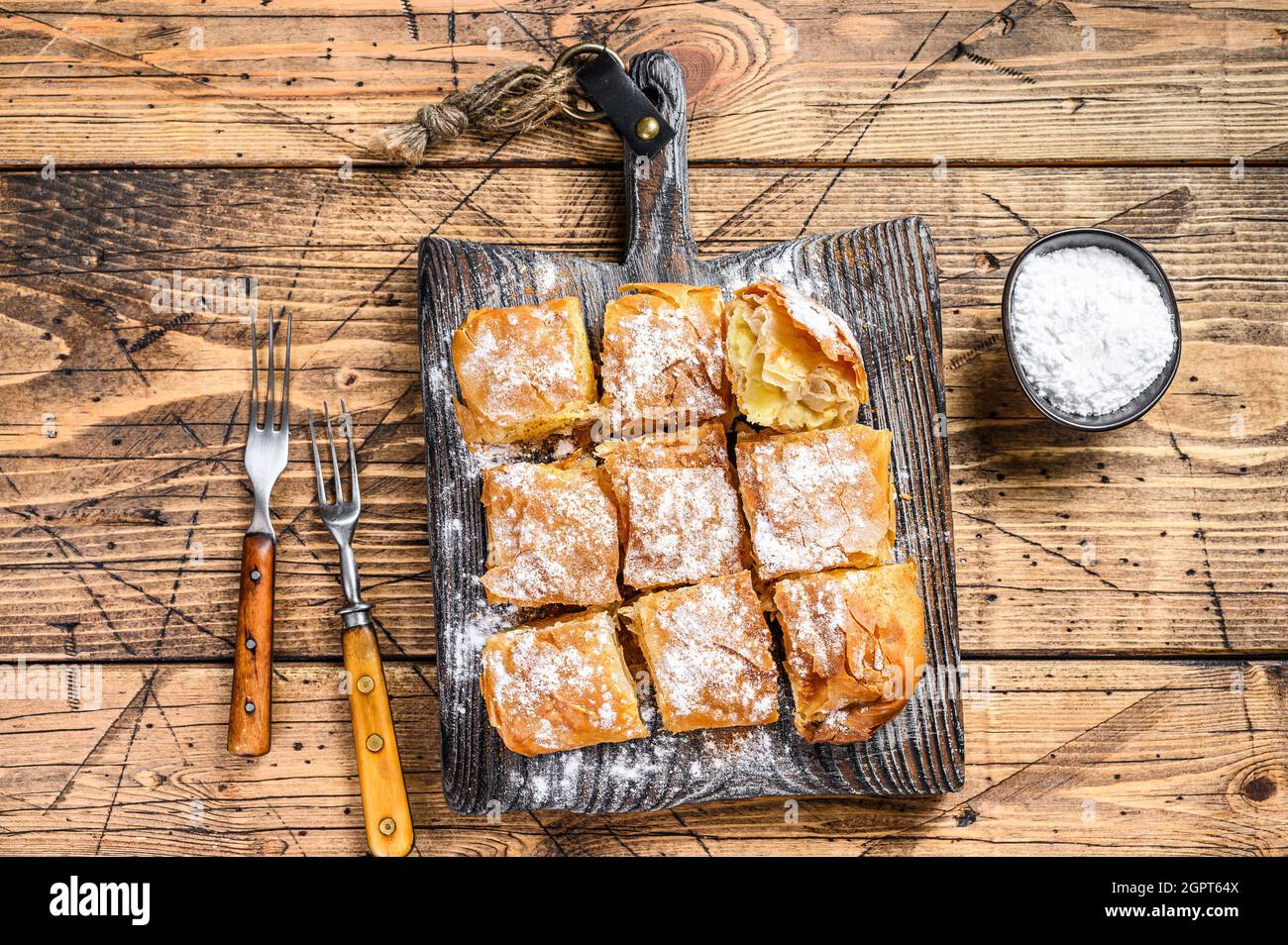 Greek pastry Bougatsa with phyllo dough and semolina custard cream. Wooden background. Top view Stock Photo